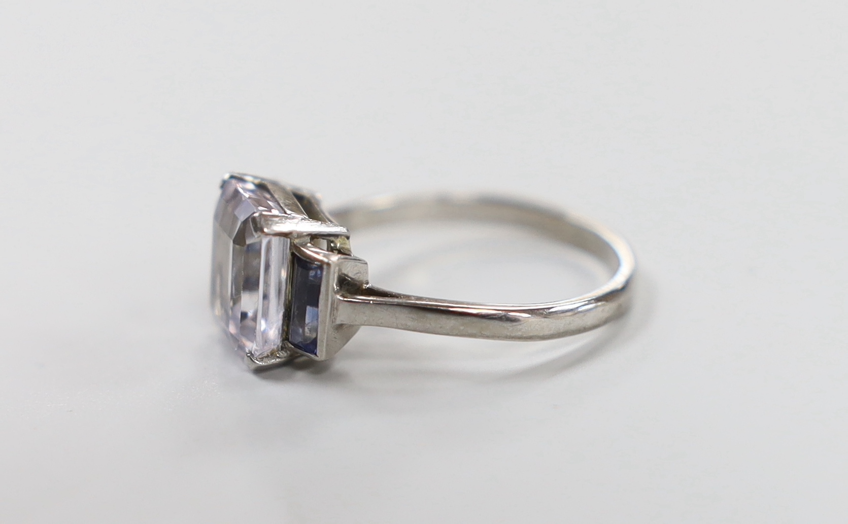A white metal and two colour sapphire set three stone ring, size N, gross weight 3.8 grams.